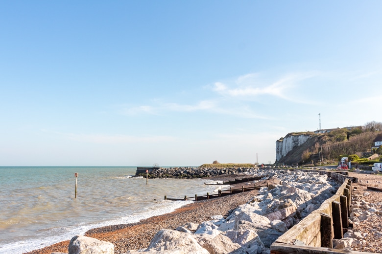 View of the stony Kingstown Beach and white chalk cliffs in the background - walk from Dover to Deal