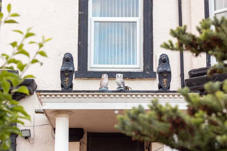 Crosby Beach, the nearest beach to Liverpool - walk around Crosby, owl statues above the entrance to a house